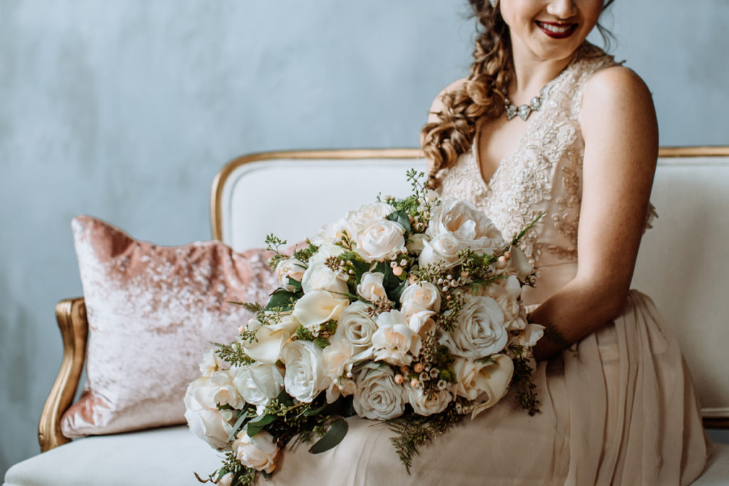 cropped portrait of a styled bride with bouquet of flowers