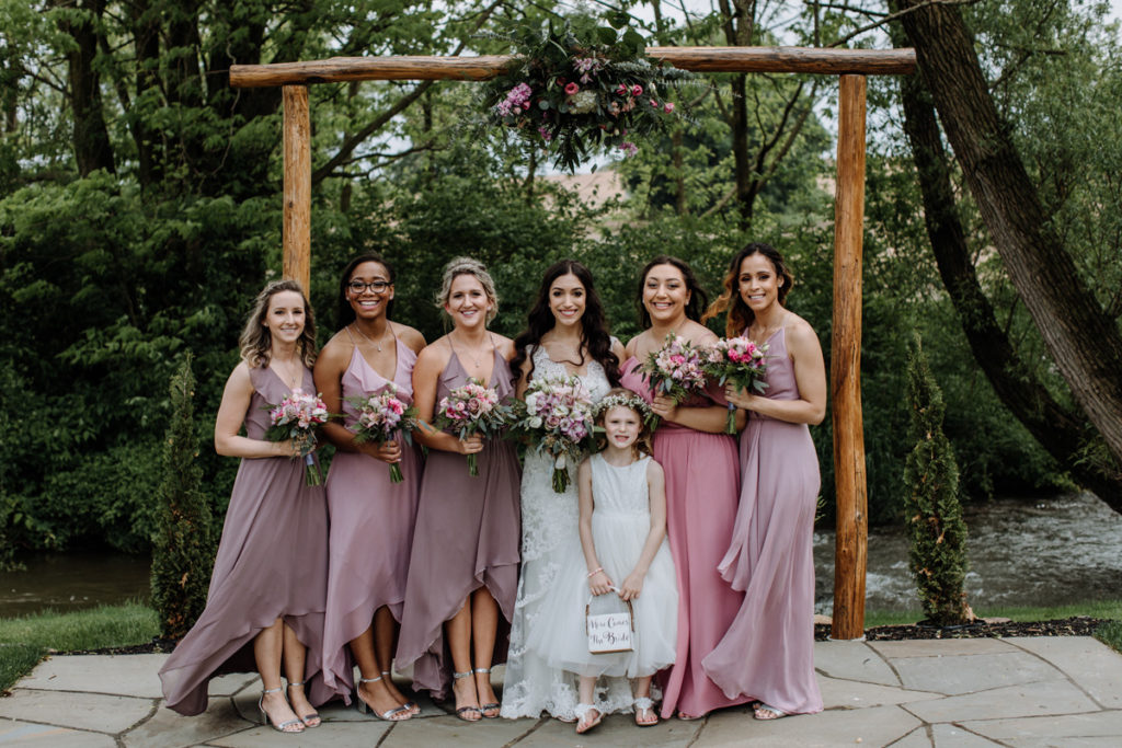 six girls (1 bride, 5 bridal party) standing for formal photograph at altar
