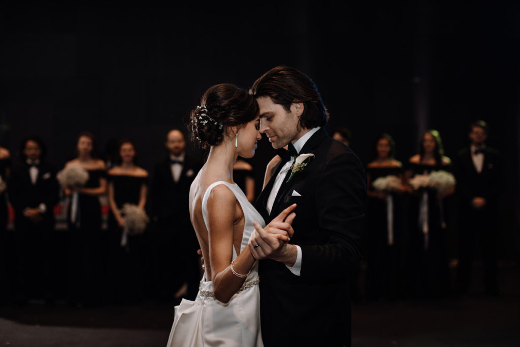 bride & groom dancing in a dark reception hall