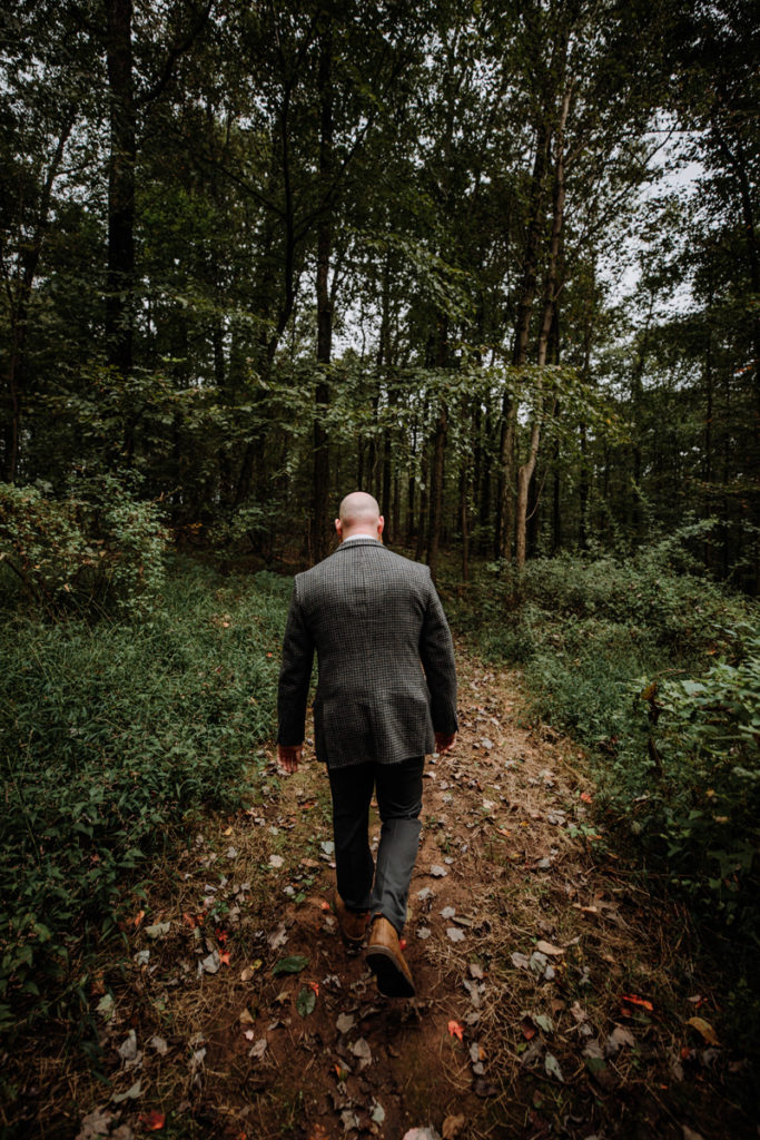 groom walks in the woods