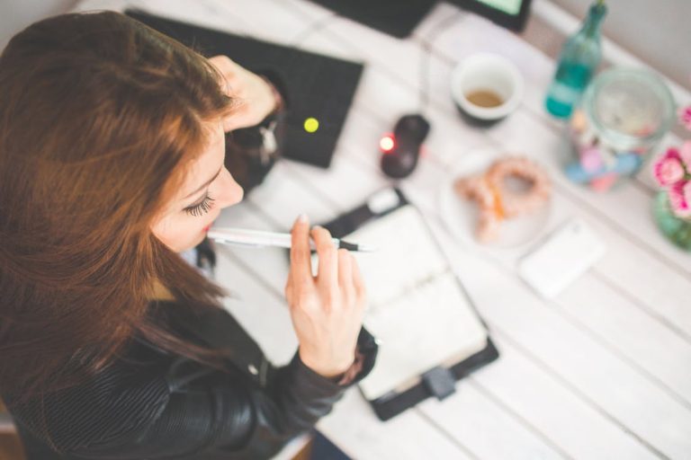 woman taking notes at desk